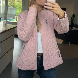 Quiltad ljusrosa jacka från Isolde - Snygg quiltad jacka i ljusrosa från Isolde, med rund hals och tre silvriga dragkedjor framtill. 