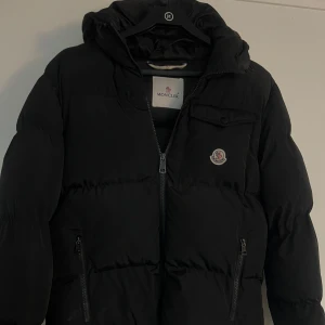 Vinterjacka från Moncler - Säljer nu min svarta, snygga vinterjacka från Moncklear. Riktigt varm o skön! Säljer den billigt pga att den har fått lite skada av smällare, har fixat den så gott det går, syns knappt. 