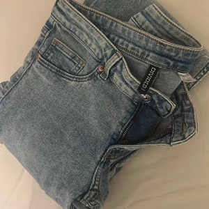 Ljusblå jeans från Divided H&M - Säljer ett par klassiska ljusblå jeans från Divided H&M. De har fem fickor, dragkedja och knapp framtill samt raka ben. Jeansen är i bomull och har en enkel, tidlös look som passar till det mesta.