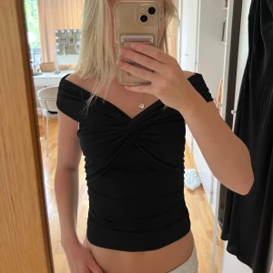 Svart topp - Snygg svart off shoulder topp med twist detalj, tajt och mjukt tyg💕