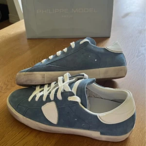 Blå Philippe Model  - Snygga blå sneakers från Philippe Model med ovandel i mocka och vita detaljer. Storleken är 43. Nypris är 3700kr, mitt pris är 2499kr. Nytt skick 