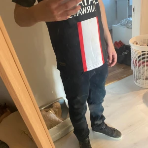 Mörkblå jeans från Dressmann - Säljer ett par mörkblå jeans från Dressmann med klassisk femficksdesign och dragkedja. Jeansen har en rak passform och är tillverkade i slitstarkt denimtyg som sitter snyggt på benen. Perfekt för dig som gillar stilrena och enkla jeans.