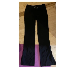 Svarta bootcut-byxor från Reject - Svarta bootcut-byxor med snyggt bälte i midjan. Storlek 34 står på lappen men de är ganska stora i storleken 