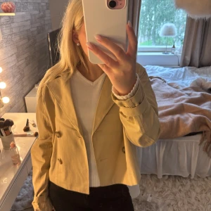 Beige Trenchcoat hm - Säljer en beige Trenchcoat från H&M med dubbelknäppning och klassisk krage. Jackan har långa ärmar, perfekt för dig som vill ha en stilren look🌸Den satt inte som jag ville där av att jag säljer den, endast testad ( prislapp kvar).