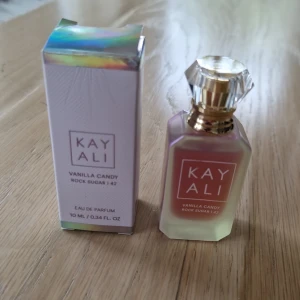 Kayali Vanilla Candy Rock Sugar 42 - Kayali Vanilla Candy Rock Sugar 42 Eau de Parfum i en lyxig, prismatisk glasflaska med guldfärgad och kristallformad kork. Söt och vaniljig doft, 10 ml.