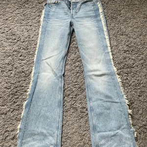 Weekday ljusblå bootcut jeans med frans - Jättecoola slutsålda jeans från weekday!! De är i storlek 24 med midjemått på 35-36 cm och innerbenslängd 83 cm💓💓i lågmidjad bootcut modell! ORGINALPRIS är 670 kr🙌🏼🙌🏼💓