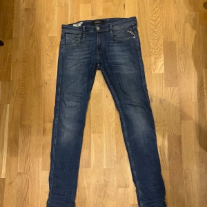 Replay Anbass slim jeans blå W30 L34 - Säljer ett par snygga Replay Anbass jeans i klassisk blå tvätt. Modellen är slim fit med normal midja och raka ben. Tillverkade i ekologisk bomull för extra komfort. Perfekta för dig som gillar stilrena och moderna jeans.