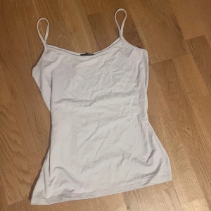 Vit linnetopp från Zara - Enkel och stilren vit linnetopp från Zara med tunna axelband. Perfekt att matcha med jeans eller kjol för en clean look. Mjuk och skön känsla, lätt att bära under varma dagar. Står storlek M men är mer som S. Jätteskönt material!!