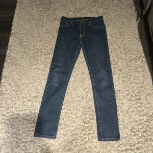 Nudie Jeans blå skinny jeans 29/34 - Snygga blå skinny jeans från Nudie Jeans. Storlek 29, 34. Jeansen har en smal passform och är tillverkade i slitstarkt denim.