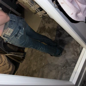 True Religion ljusblå bootcut jeans - Säljer ett par ljusblå jättesnygga bootcut jeans från True Religion med låg midja i strlk 25. Jeansen har snygga fickdetaljer med lock och silverknappar bak. Modellen heter Joey Low Rise Flare. Köpta för 1299kr, säljer för 699+frakt. 