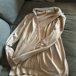 Beige ziptröja från Selected Homme XXL - Beige långärmad ziptröja från Selected Homme i storlek XXL. Tröjan har hel dragkedja framtill, mjuk känsla och klassisk krage. Perfekt för lager-på-lager och chill stil. Tillverkad i bomullsmix för skön komfort.