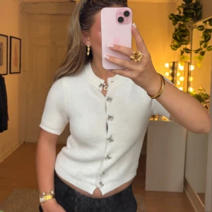 Vit kofta - Jätte söt stickad kofta med silvriga rosett knappar. Jag köpte denna tröja då jag tyckte den va så fin men insåg sedan att den inte passade när jag bara använde guldsmycken därav är den inte använd alls. Tröjan är super mjuk och väldigt väldigt varm, perfekt till vintern och hösten. Kolla i bion innnan köp. Märke: Zara storlek: S