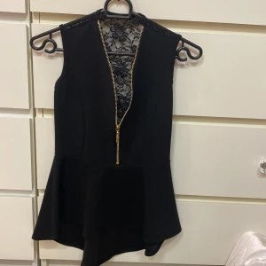 Top  - Snygg top med guldfärgad dragkedja. Längre baktill. Och spetstyg i ryggen. 