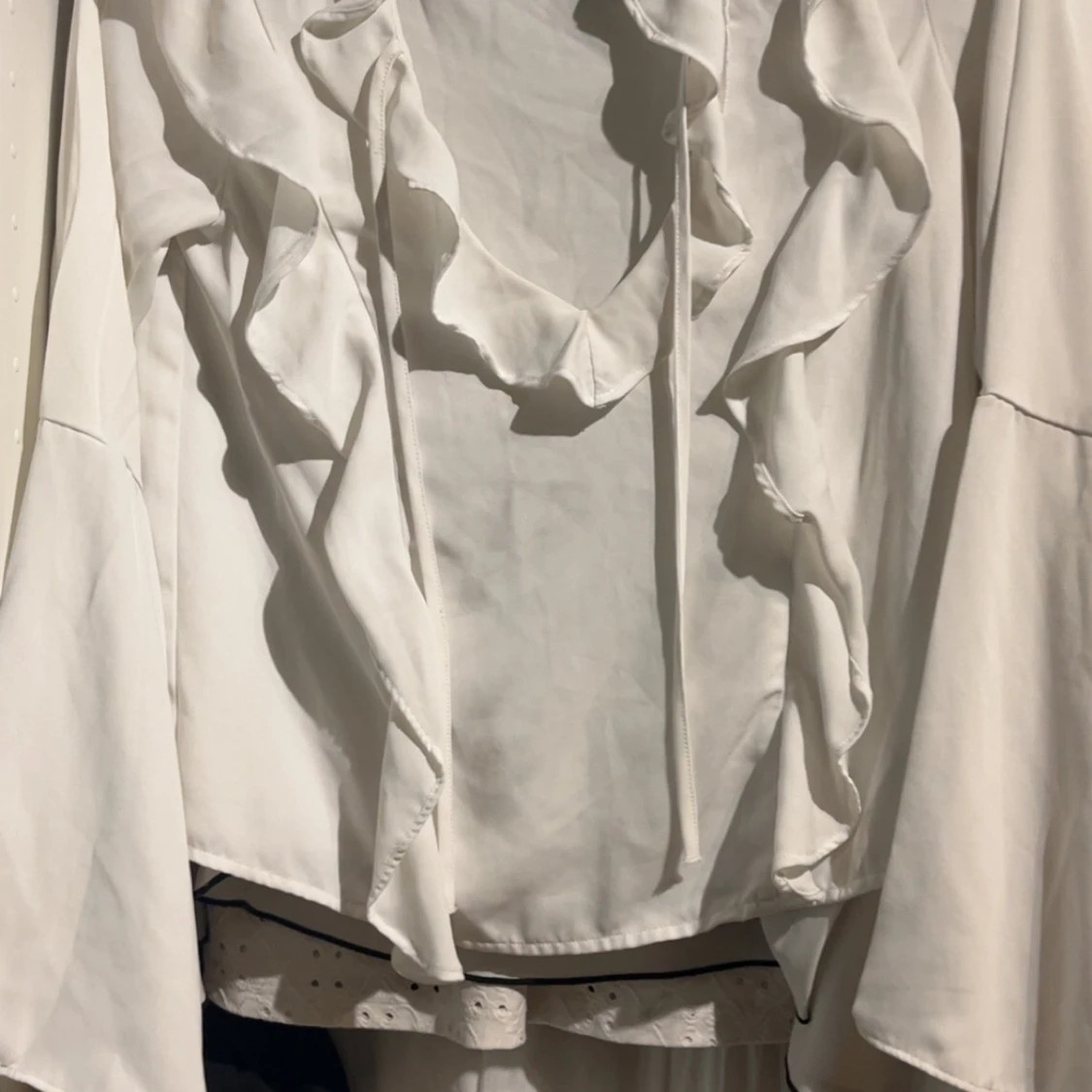 Vit blus med volanger och knyt