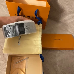 Louis Vuitton vit bälte  - Helt nytt och oanvänt,Exklusivt Louis Vuitton bälte i vit färg med ett stilrent silverfärgat LV-spänne. Bältet har en modern och clean look med inslag av svart vid spännet. Kommer med originalförpackning, dustbag och kvitto. Perfekt accessoar för att lyfta din outfit. Säljs pga fel storlek