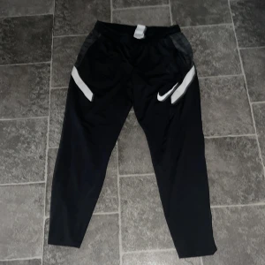 Svarta träningsbyxor från Nike - Nike träningsbyxor, se bild 3, det finns ett litet hål vid dragkedjan som man inte märker av 