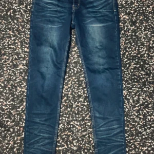 Replay Anbass skinny jeans blå - Snygga Replay Anbass jeans i mörkblå tvätt med skinny passform. Klassisk femficksmodell med gul kontrastsöm och broderade bakfickor. Jeansen har låg midja och är tillverkade i stretchig denim för skön komfort. Perfekt för dig som gillar en smal siluett.