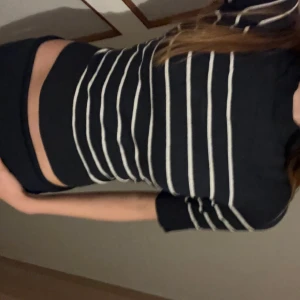 Marinblå och vit randig stickad tröja - Marinblå stickad tröja från 157 med vita horisontella ränder. Modellen är croppad med trekvartsärm och har en rund hals. Perfekt för dig som gillar enkel och stilren design med lite edge. Materialet är mjukt och stretchigt för skön passform.