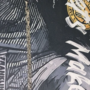 Kedjearmband i silverfärg - Stilrent armband med robust kedjedesign i silverfärg. Länkarna är rektangulära och sitter tätt ihop för en modern och edgy look. Perfekt för dig som gillar minimalistiska men ändå iögonfallande accessoarer.