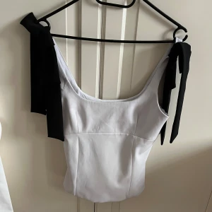 Zaratopp - Superfint topp från Zara med svarta rosetter på ärmen. Enbart använd tre gånger så den är i jättebra skick. Storlek xs🩷