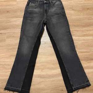 Svarta bootcut jeans från Zara - Snygga svarta jeans från Zara i bootcut-modell med råa, fransiga benslut. Jeansen har klassisk femficksdesign och en mörk tvätt med lätt slitning. Passar dig som gillar en lite bredare siluett och coola detaljer.