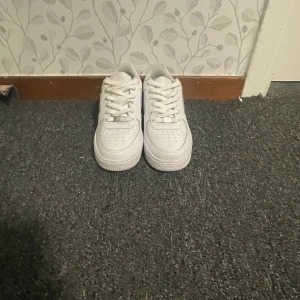 Nike Air Force 1 vita sneakers - Fräscha vita Nike Air Force 1 sneakers som jag säljer. Har använt de max 2 gånger och de är helt vita. Nypris är 1200 men säljer den för 800