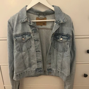 Ljusblå jeansjacka med knappar - ljusblå jeansjacka från lager 157 med snygga bröstfickor och silverfärgade knappar.