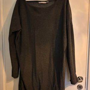 Glittrig svart klänning House of Lola - Svart långärmad klänning från House of Lola i storlek L. Materialet har en glittrig finish som ger en snygg shimmer-effekt. Klänningen har enkel, rak passform och rund halsringning. Perfekt för dig som gillar stilrena plagg med lite extra glans.