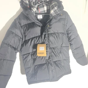 Burberry jacka  - Tjena! Nu säljer vi en sjukt fet jacka från burberry. Den är helt oanvänd och aldrig testad, så du som köper är den första som kommer att bära den! Den har det klassiks mönstret i luvan som alla känner till. Den är otroligt bra kvalité och väldigt varm och skön. Den har avtagbara armar som gör det perfekt för både vintertid och vår/höst. Vi är seriösa säljare från Skåne som alltid skickar varan inom ett dygn. Hör av er vid minsta fråga. Tack för ni handlar hos oss!✨🤩