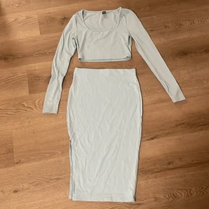 Ljusblå ribbat set ifrån Shein - Säljer ett ljusblått set från Shein . Setet består av en croppad långärmad topp med rundad hals och en långkjol med slits på sidan. Perfekt för dig som gillar stilrena och trendiga looks.