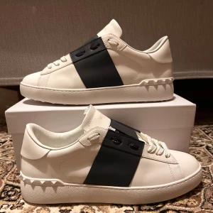 Valentino Garavani Open sneakers vit/svart - Snygga Valentino Garavani Open sneakers. Skorna är sparsamt använda och i jätte fint skick. Pris är inte hugget i sten så KOM MED BUD!!!!