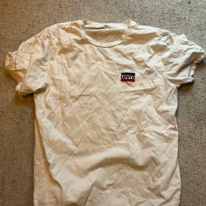 Vit slim t-shirt från Levi's XL - Vit t-shirt från Levi's i slim fit med klassisk logga på bröstet i svart, vitt och rött. Finns fläckar, vet inte vart dem kommer ifrån och har heller inte provat att få bort. Bara ett fynd i garderoben som jag vill bli av med