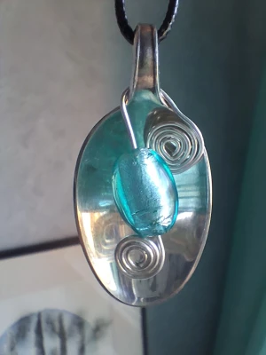 Handgjort halsband återbruk  - Egentillverkat halsband skapat med en sked gjord i nysilver samt aluminiumtråd och en turkos pärla. Hänget är ca 5cm långt. Bandet är justerbart på halsbandet. Blir en unik accessoar 