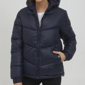 Mörkblå pufferjacka från Oxmo - Snygg mörkblå/marinblå pufferjacka från Oxmo i storlek M. Jackan har huva, dragkedja framtill och två fickor med knappdetalj. 🥰