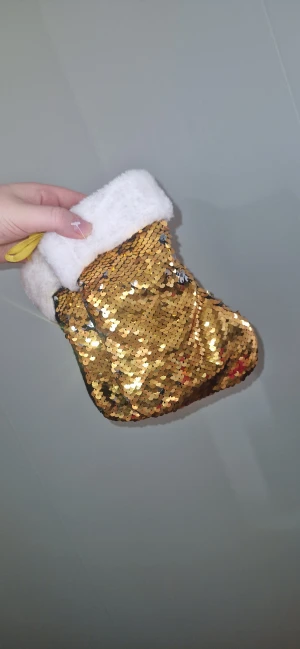 2 julstrumpor  - 2st små fina julstrumpor- Med vändbara paljetter i guld och silver. Dra handen uppåt för att få en skimrande silveryta – dra nedåt för att låta strumpan glänsa i guld. En magiskt glittrig detalj som lyser upp julen!