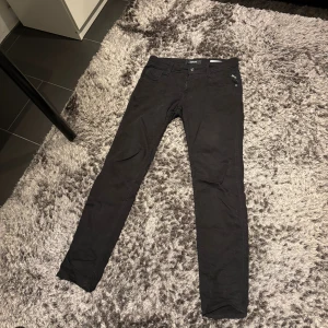 Svarta Replay Anbass slim jeans - Svarta Replay Anbass jeans i slim fit med klassisk femficksdesign och snyggt smal siluett. Byxorna är tillverkade i mjukt jeanstyg med stretch för extra komfort. Passar dig som gillar en modern och stilren look.