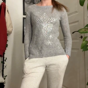 Grå stickad tröja med paljettsnöflingor - Snygg stickad tröja med julmönster, storlek xxs och inga hål eller liknande.