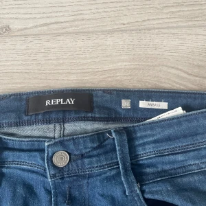 Replay Anbass jeans blå herr - Snygga blå Replay Anbass jeans i klassisk femficksmodell. Jeansen har en rak passform med smalare ben och är tillverkade i mjukt jeansmaterial med lätt stretch. Stilsäker design med Replay-logga på bakfickan och läderpatch i midjan.