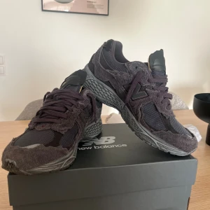 Grå New Balance sneakers 2002 storlek 44 - Säljer ett par grå New Balance sneakers med chunky sula och coola detaljer i grov mocka och mesh. Skorna har snörning och rund tå, och den robusta designen ger en unik vibe. Perfekt för dig som gillar streetwear och vill sticka ut med din stil. Använt ungefär 5 ggr