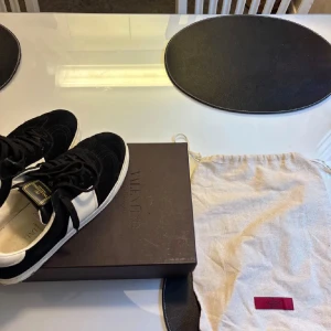 Valentino Garavani svartvita  - Svartvita sneakers från Valentino Garavani med snygg kontrast mellan svart mocka och vita skinnpaneler. Dem är storlek 41 men passar även 42. Skriv om du har frågor.