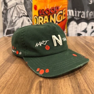 NART Keps - Säljer en grön keps från NART med broderad logga och vita detaljer. Kepsen har röda prickar som cool detalj och en stor tygpatch baktill med text och signatur. Justerbar snapback och soft passform. Målarhinken medföljer! Använd vid ett tillfälle (Sandstock Festival) så så gott som helt ny. Nypris 3000kr, säljer för 1899kr! Allt gott, Brur!🫰🏽