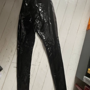 Vinyl byxor - Vinyl byxor från new look. Skulle tro att dessa passar någon i XS bäst. Jag kan mötas upp i Uddevalla centrum, annars fraktar jag gärna. Köparen står för frakten. (Står ej för postens slarv) katt finns i hemmet. 