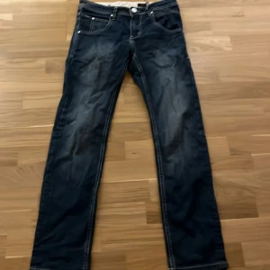 Jeans - Snygga mörkblå jeans från Gabba med raka ben och kontrastsömmar. Jeansen har klassisk femficksdesign, coola detaljer på bakfickorna och Gabba-logga vid fickan. Perfekta för dig som gillar stilrena och tidlösa jeans med en modern touch. Nypris över 1000kr mitt pris under 400