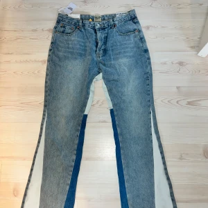Gallery Dept. jeans med kontrastpaneler - Unika blå jeans från Gallery Dept. med ljusa kontrastpaneler längs benen. Klassisk femficksmodell, läderpatch bak och coola detaljer. Raka ben med bred passform och snygg tvättad denimlook. Perfekta för dig som vill sticka ut med din stil. 0bs lnte 0rglnal!