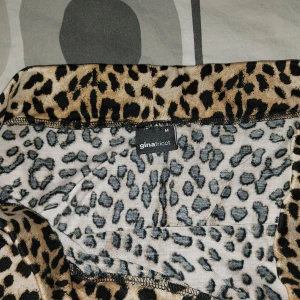 Leopardmönstrad långkjol Gina Tricot - Säljer en snygg långkjol från Gina Tricot med leopardmönster i beige, svart och bruna toner. Kjolen har en rak passform och är tillverkad i ett mjukt, lätt material som känns skönt mot huden. Perfekt för dig som vill sticka ut med ett djurmönster. Slits vid ena sidan. Storlek:M