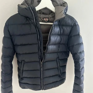 Mörkblå dunjacka från Colmar - Snygg mörkblå dunjacka från Colmar med huva och dragkedja framtill. Jackan har quiltad design, två fickor med dragkedja och en klassisk logga på ärmen. Pris kan diskuteras skriv för fler bilder!🌸