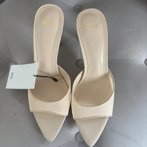 Beige klackade sandaler från Mango - Snygga beige klackar från MNG med spetsig tå.  Passar till många olika outfits och ger en elegant touch. Dom är även helt oanvända 