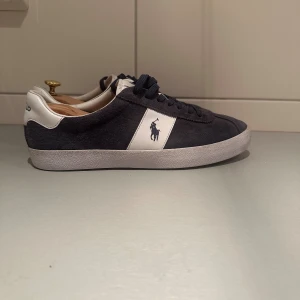 Mörkblå sneakers från Polo Ralph Lauren - Snygga mörkblå sneakers från Polo Ralph Lauren.       Använda fåtal gånger som nya.                                                      Storlek 43.                                                            Nypris ca 1000kr