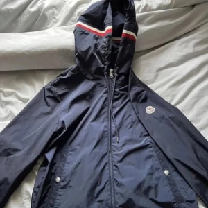 Moncler vindjacka - Säljer denna jackan då den ej passar mig, den är i super skick och knappt använd. Storlek XL men passar dig som har L. Priset är fast så kommer inte gå ner något.
