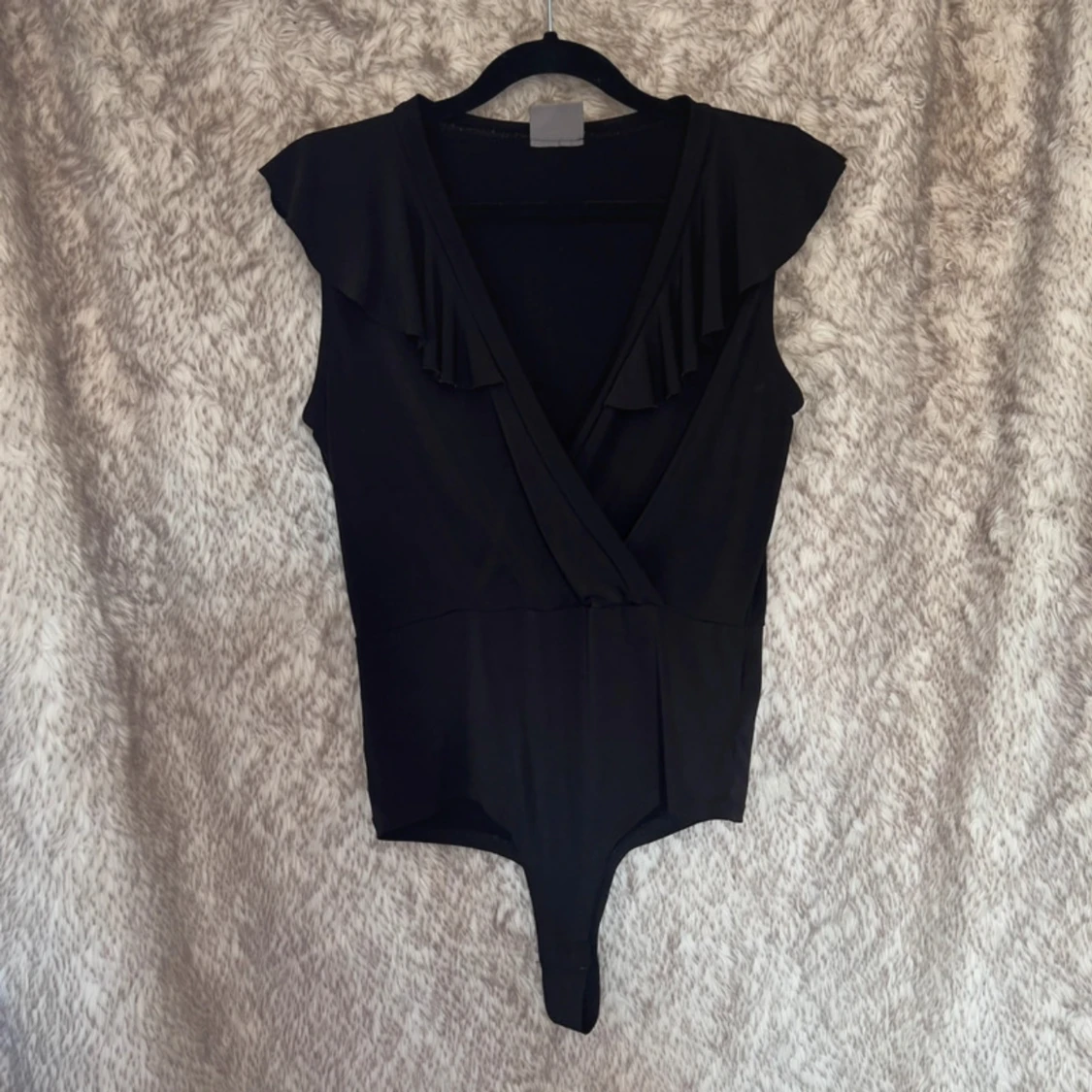 Svart omlott bodysuit med volang